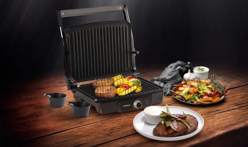 Orava Grillchef na stole s grilovanou zeleninou a mäsom